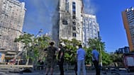People look at a burning office building following a Russian drone attack in central Odesa, Ukraine, Friday, Sept. 18, 2026.