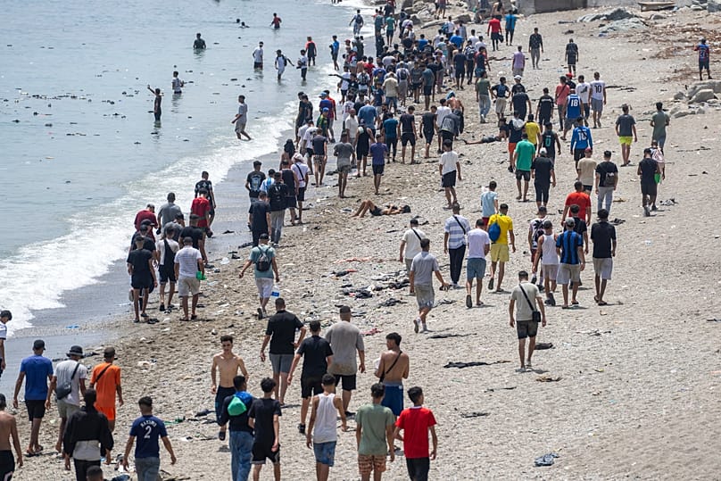 People walk on a beach after attempting to cross from the Moroccan northern town of Fnideq to the Spanish enclave of Ceuta, July 31, 2026.