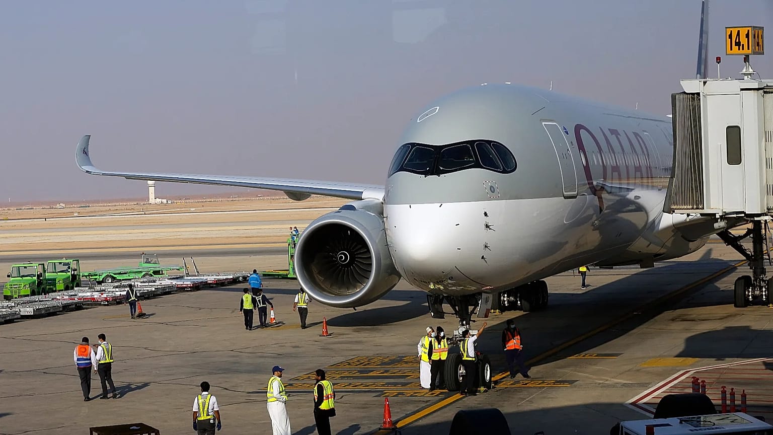 Saudi airport officials surround a Qatar Airways plane at King Khalid Airport in Riyadh, Saudi Arabia, Monday, Jan. 11, 2021.