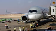 Saudi airport officials surround a Qatar Airways plane at King Khalid Airport in Riyadh, Saudi Arabia, Monday, Jan. 11, 2021.