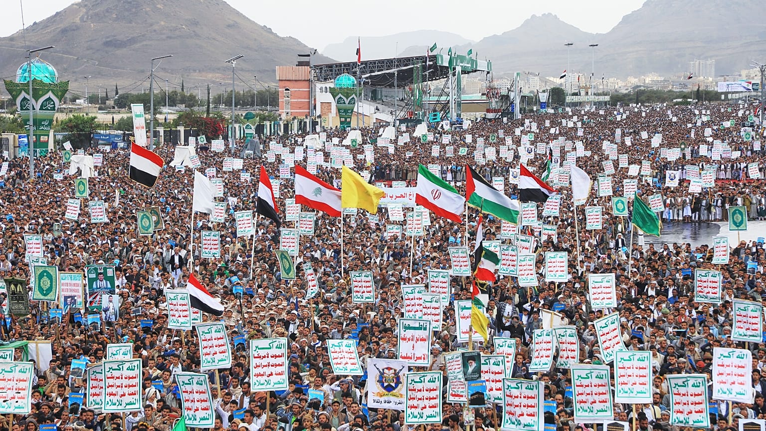 Supporters of Yemen’s Houthi rebels raise Yemeni, Lebanese and Iranian flags during a rally in support of the group.