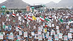 Supporters of Yemen’s Houthi rebels raise Yemeni, Lebanese and Iranian flags during a rally in support of the group.