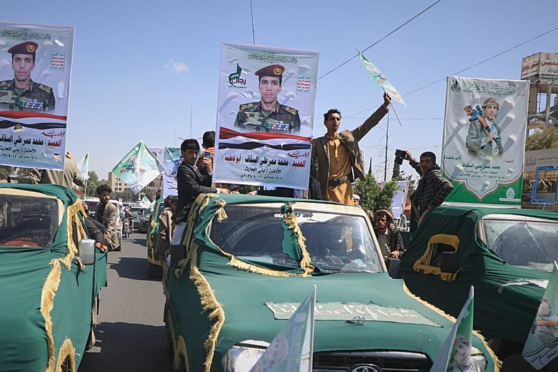 Pickup trucks travel in a mass funeral procession for Houthi officers and other military personnel in Sanaa, Yemen, Wednesday, Sept. 16, 2026.