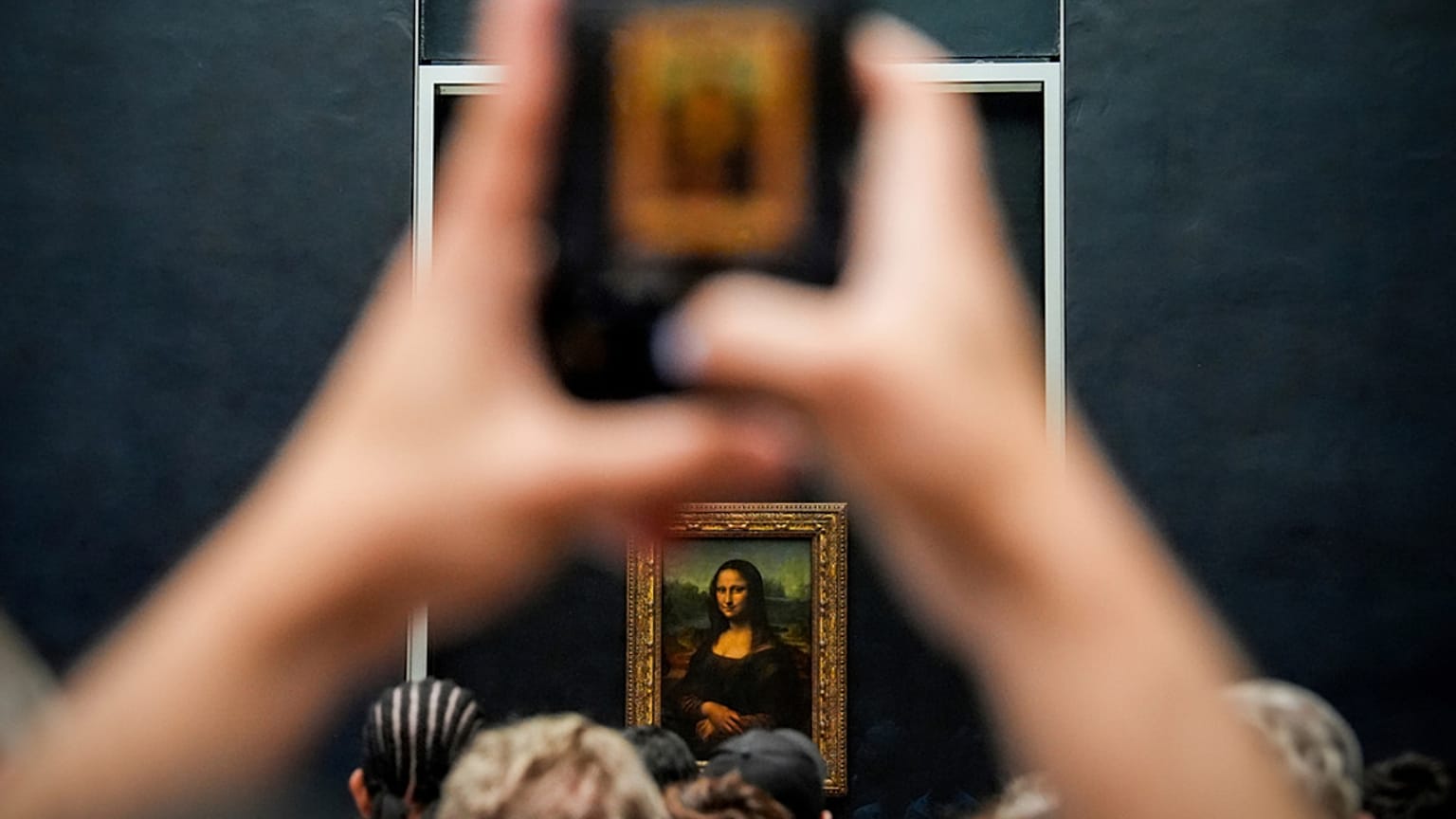 Mona Lisa tablosunu görüntüleyen ziyaretçi