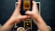 Mona Lisa tablosunu görüntüleyen ziyaretçi