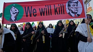 نساءٌ تابعاتٌ للحرس الثوري الإيراني يحملن بنادق أثناء مسيرهن تحت لافتةٍ تُظهر الرئيس الأمريكي دونالد ترامب في مرمى التصويب، طهران، إيران، يوم الجمعة، 18 سبتمبر 2026.