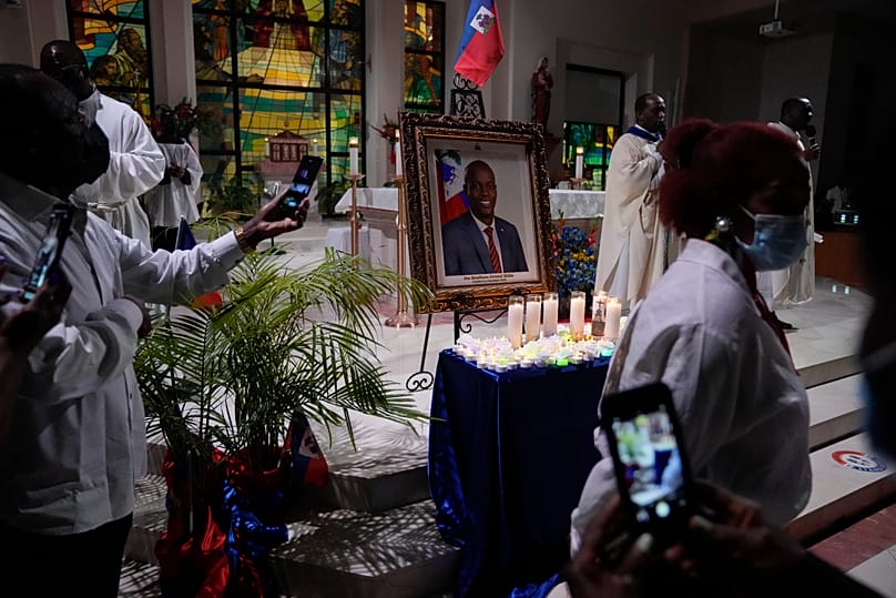 Mourners in front of a portrait of Haiti's assassinated President Jovenel Moïse during a memorial service at Notre Dame d'Haiti Catholic Church in Miami, 22 July, 2021