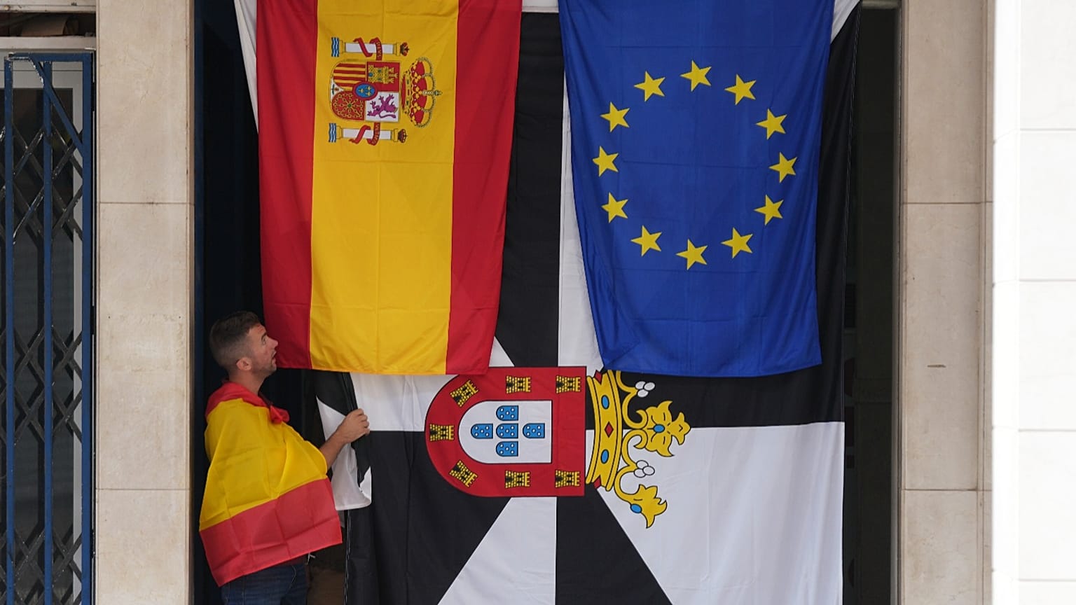 Un hombre permanece junto a las banderas de España, la UE y Ceuta durante una manifestación de apoyo a la ciudad, en el enclave español de Ceuta, el 2 de septiembre de 2026.