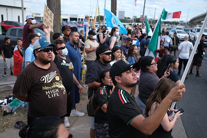 People protest at the site where local authorities say an ICE officer shot and wounded a man in Austin, 20 September, 2026