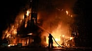 A rescue worker puts out a fire at the Intrade trade centre after a Russian drone strike on Zaporizhzhia, 21 September, 2026
