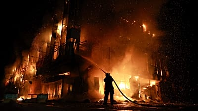 A rescue worker puts out a fire at the Intrade trade centre after a Russian drone strike on Zaporizhzhia, 21 September, 2026
