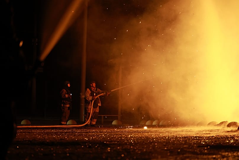 Um elemento das equipas de socorro extingue um incêndio no centro comercial Intrade após um ataque de drone russo em Zaporíjia, 21 de setembro de 2026