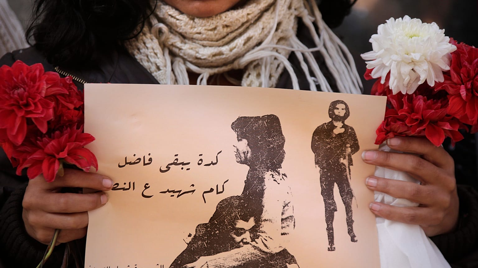 يحمل متظاهر مصري لافتة عليها صورة الناشطة شيماء الصباغ -التي قُتلت بالرصاص خلال احتجاج سلمي صغير يوم السبت الماضي- وعبارة بالعربية تقول "كم شهيداً متبقياً للنصر"، وذلك أثناء ا