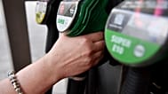 Um cliente estende a mão para a bomba de combustível numa estação de serviço em Berlim, sexta-feira, 13 de junho de 2025