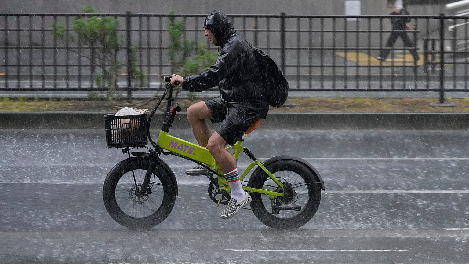 Un ciclista circula bajo una lluvia intensa y repentina en Tokio, el 13 de agosto de 2026.
