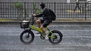 Un ciclista circula bajo una lluvia intensa y repentina en Tokio, el 13 de agosto de 2026.