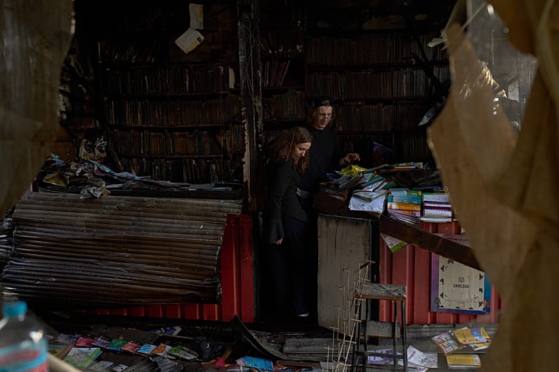 Pessoas observam os estragos no dia seguinte a um ataque de míssil russo num mercado de livros da cidade, em Kiev, 17 de agosto de 2026