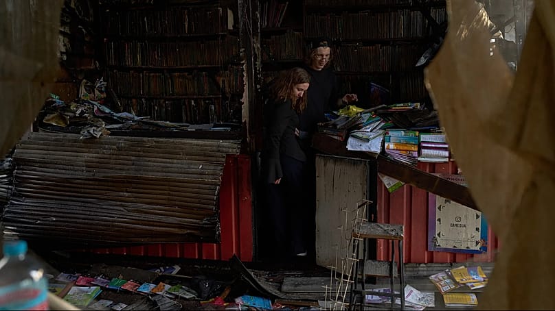 Menschen betrachten die Zerstörungen einen Tag nach einem russischen Raketenangriff auf einen städtischen Buchmarkt in Kyjiw, 17. August 2026