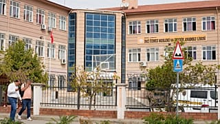 People walk past a vocational and technical high school in the Turgutlu district of Manisa province, 22 September, 2026