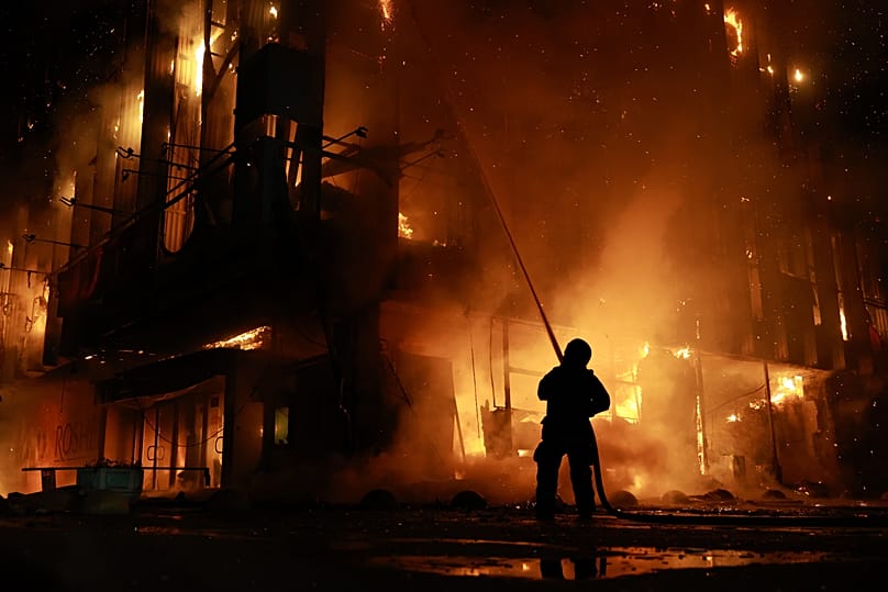 A rescue worker puts out a fire at the Intrade trade centre after a Russian drone strike on Zaporizhzhia, 21 September, 2026