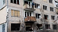 A man stands on a balcony of an apartment building damaged after a Russian drone strike in Kyiv, 22 September, 2026