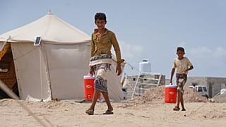 نازحون يمنيون يحملون المياه في مخيم الفردوس غرب عدن، 21 أيلول 2026.