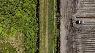 Vista aérea de un trabajador arando la tierra con su tractor
