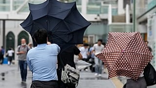 Un hombre con paraguas lucha contra el fuerte viento del tifón Ampil mientras camina por una calle de Tokio, el viernes 16 de agosto de 2024.