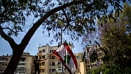 متظاهر مناهض للحكومة يلوح بالعلم اللبناني خلال الاحتجاجات المستمرة ضد الحكومة اللبنانية خارج قصر العدل في بيروت، لبنان، الخميس 7 مايو 2020.
