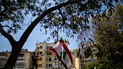 متظاهر مناهض للحكومة يلوح بالعلم اللبناني خلال الاحتجاجات المستمرة ضد الحكومة اللبنانية خارج قصر العدل في بيروت، لبنان، الخميس 7 مايو 2020.
