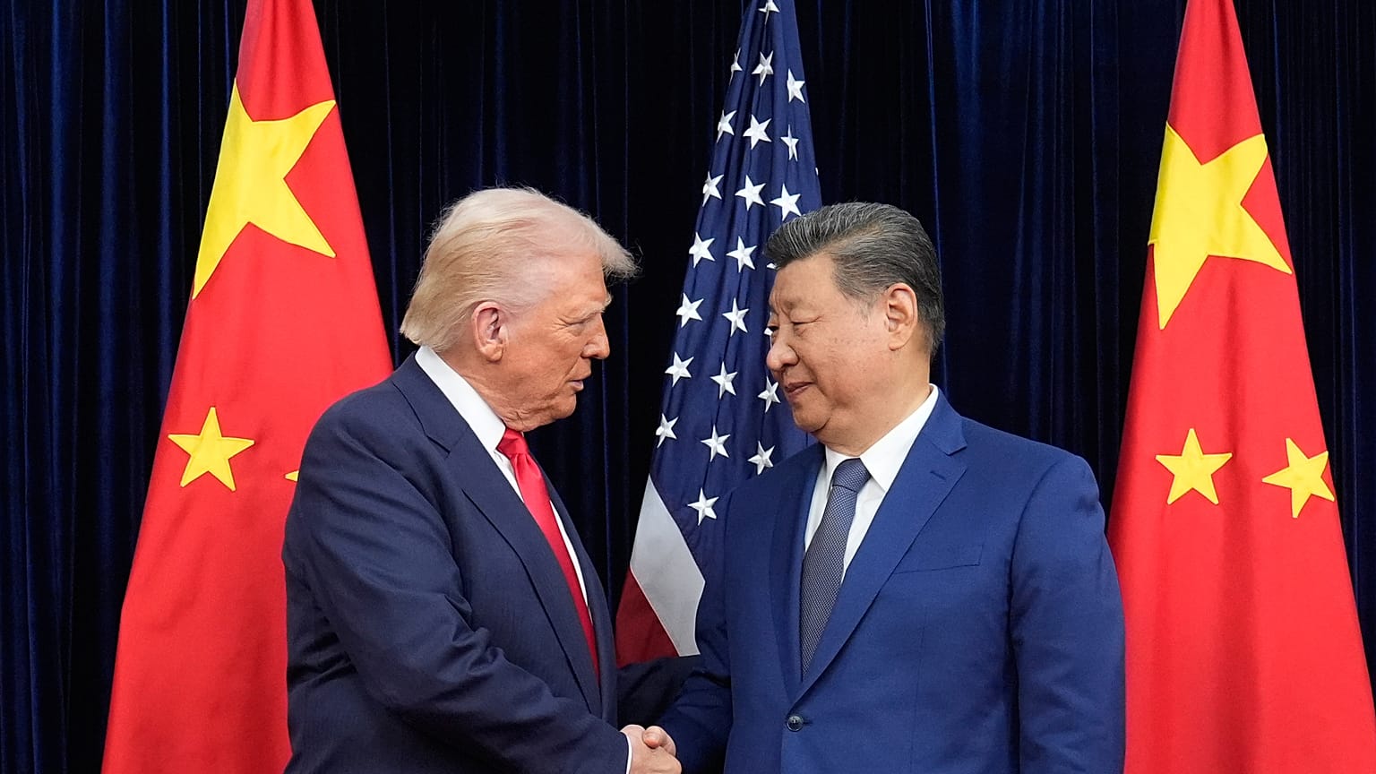 President Donald Trump, left, and Chinese President Xi Jinping, right, shake hands before their meeting at Gimhae International Airport in Busan, South Korea, Oct. 30, 2025.