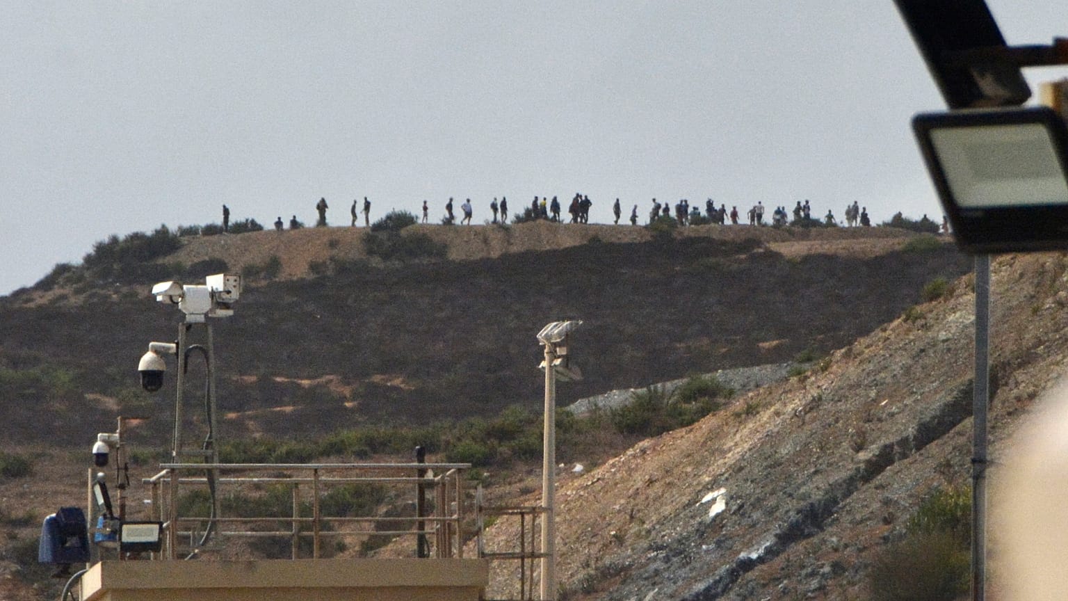 Archivo: Varias personas permanecen junto a la frontera de Tarajal, en el enclave español de Ceuta, el domingo 15 de septiembre de 2024. 
