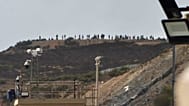 Archivo: Varias personas permanecen junto a la frontera de Tarajal, en el enclave español de Ceuta, el domingo 15 de septiembre de 2024. 