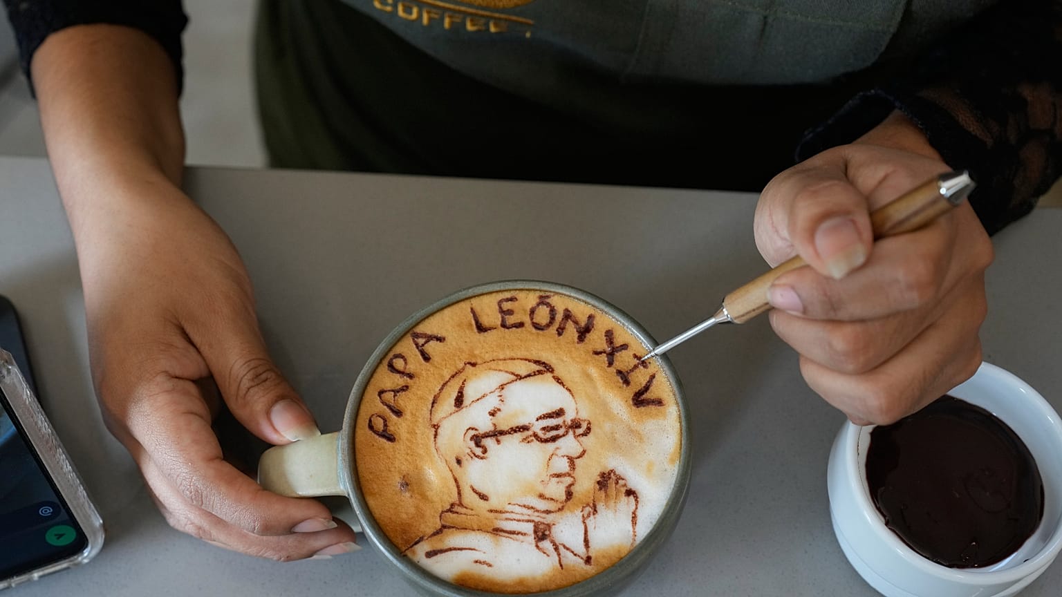 A barista Ariana Mallma decora um cappuccino com um desenho do papa Leão XIV no café Ynn Coffee, em Lima, Peru, terça-feira, 22 de setembro de 2026.