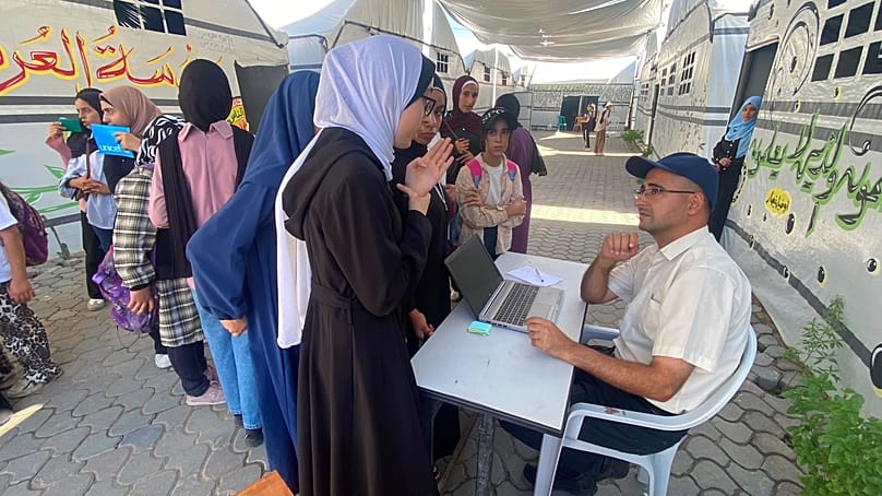 تلميذات أمام خيمة أقيمت فوق أنقاض مدرسة العروبة الثانوية التي دمّرها القصف الإسرائيلي، مخيم النصيرات، وسط قطاع غزة
