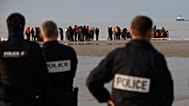 French police officers watch migrants returning to the beach after a failed attempt to reach Britain in Gravelines, 6 November, 2025