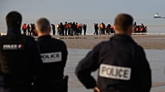 Fransız polisleri, Gravelines'de Birleşik Krallık'a geçme girişimi başarısız olan göçmenlerin sahile dönüşünü izliyor, 6 Kasım 2025