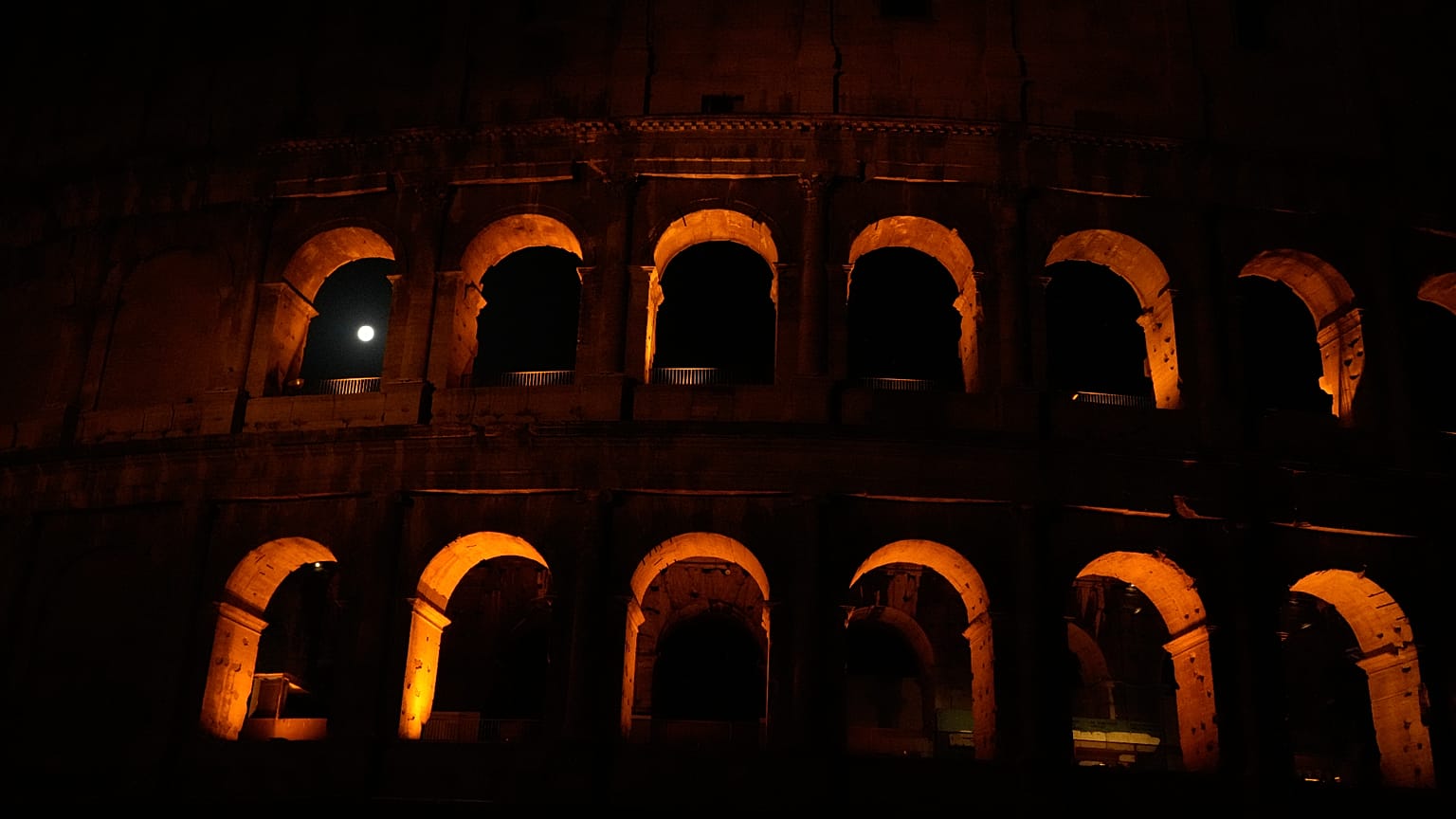 The moon sets behind the Colosseum during a partial lunar eclipse in Rome, Friday, Aug. 28, 2026