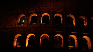 The moon sets behind the Colosseum during a partial lunar eclipse in Rome, Friday, Aug. 28, 2026