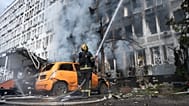 Firefighters extinguish a fire at a burning building following a Russian drone strike in Kyiv, 23 September, 2026