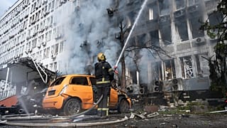 Firefighters extinguish a fire at a burning building following a Russian drone strike in Kyiv, 23 September, 2026