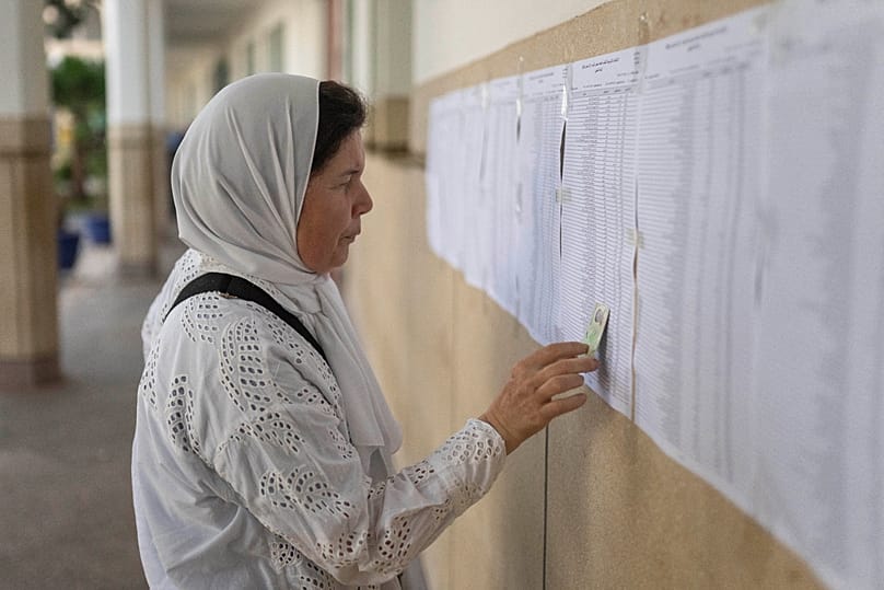 A woman checks voters' lists before casting her vote inside a polling station during the legislative elections in Rabat, 23 September 2026