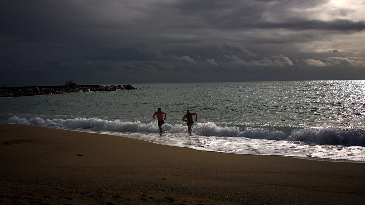 Dos turistas salen del mar Mediterráneo tras nadar en Barcelona, ​​España, el martes 3 de febrero de 2026.
