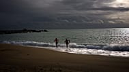 Dos turistas salen del mar Mediterráneo tras nadar en Barcelona, ​​España, el martes 3 de febrero de 2026.