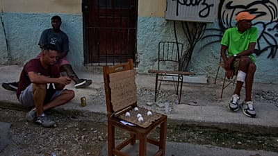 Algumas pessoas conversam junto a ovos à venda numa rua durante um apagão em Havana, Cuba, sexta-feira, 18 de setembro de 2026.