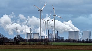 Renewable and fossil-fuel energy is produced when wind generators are seen in front of a coal fired power plant near Jackerath, Germany, Friday, Dec. 7, 2018.