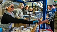 Staff serve meals to students at a university canteen following the introduction of €1 meals for all students in France.