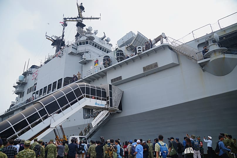 Militari e giornalisti indonesiani si riuniscono accanto alla Garibaldi, ex portaerei della Marina italiana, al suo arrivo al porto di Tanjung Priok a Giacarta