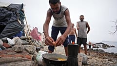 Migrantes cocinan cerca de sus tiendas de campaña en la playa de El Trampolín, en el enclave español de Ceuta, el miércoles 2 de septiembre de 2026.