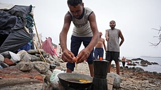 Migrantes cocinan cerca de sus tiendas de campaña en la playa de El Trampolín, en el enclave español de Ceuta, el miércoles 2 de septiembre de 2026.